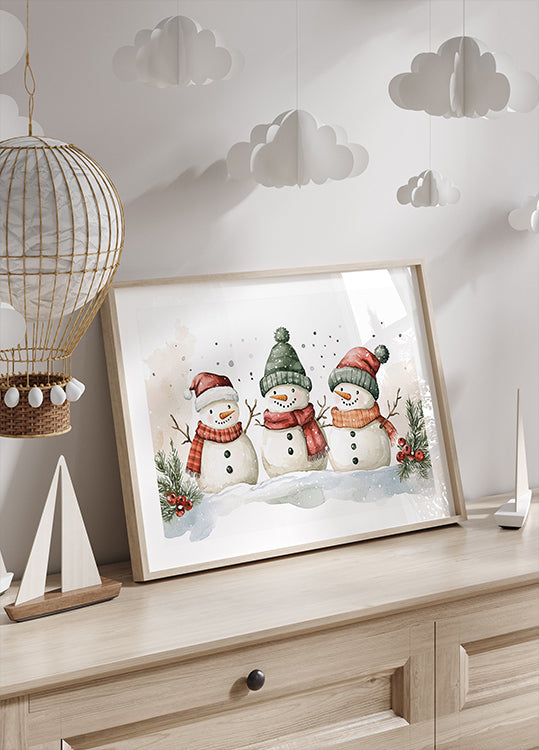 a picture of three snowmen on a dresser