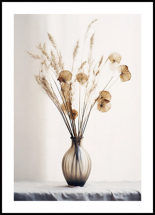 a vase filled with dried flowers on top of a table