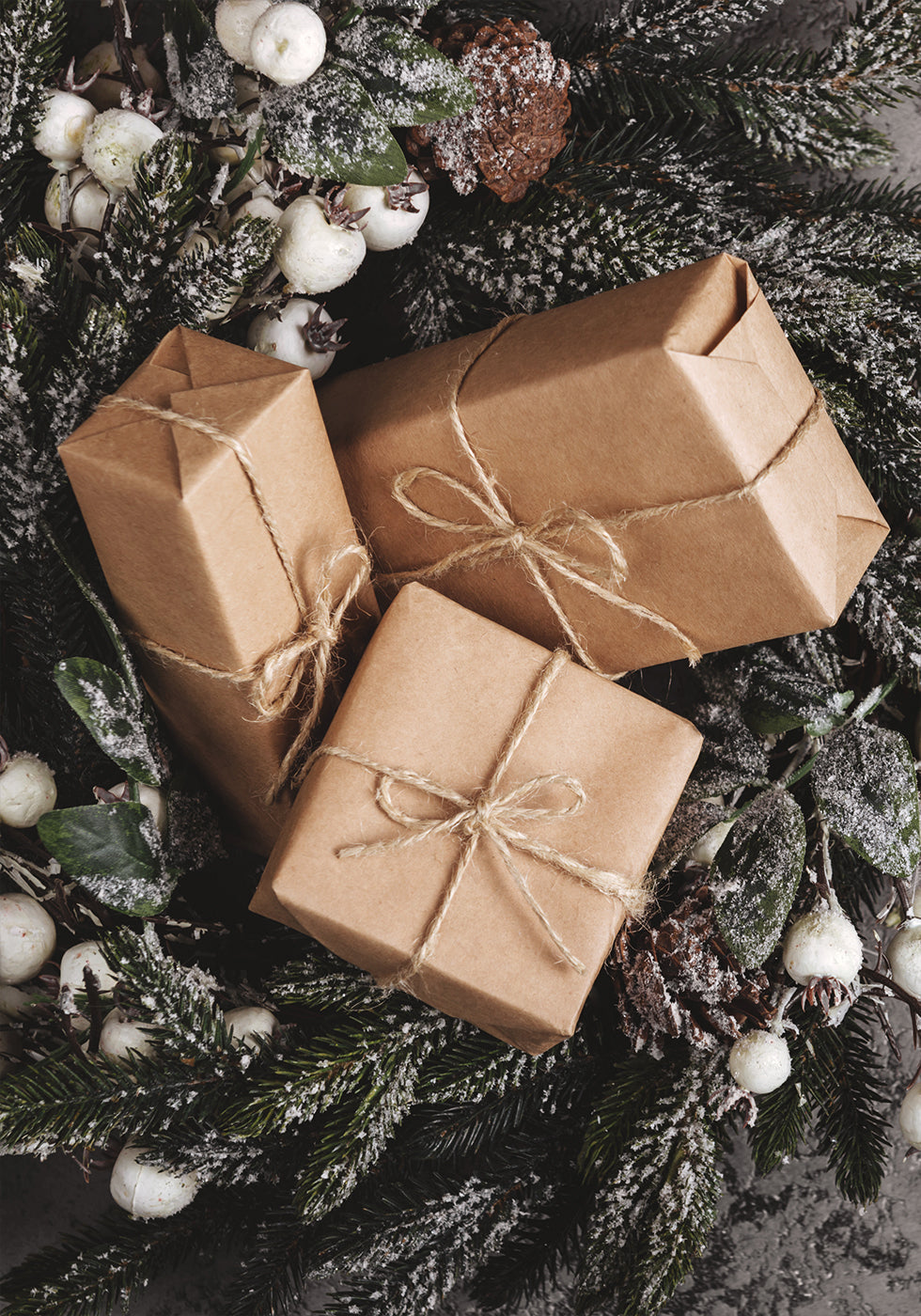 two wrapped presents sitting on top of a christmas wreath