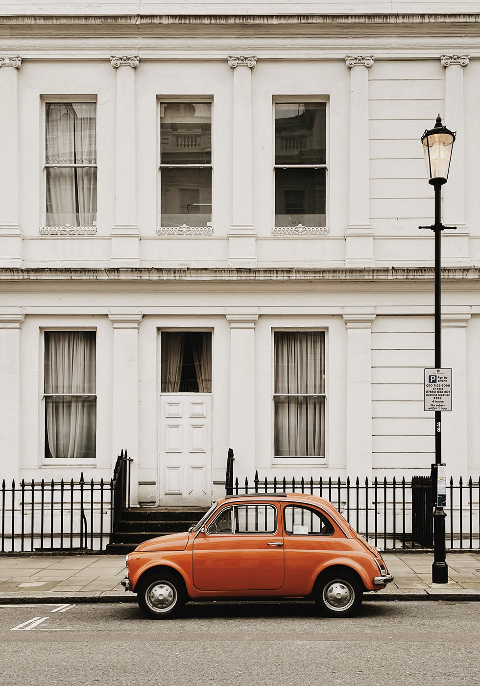 Poster Charmante Stadtszene mit orange Auto