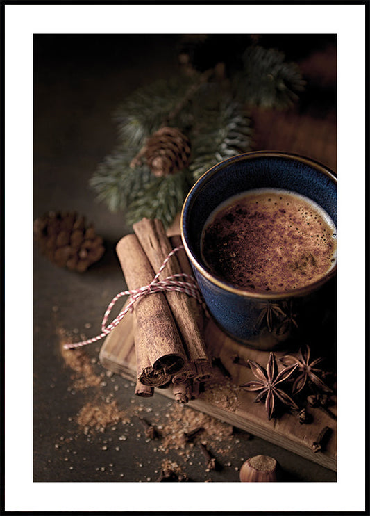 a cup of hot chocolate next to cinnamon sticks